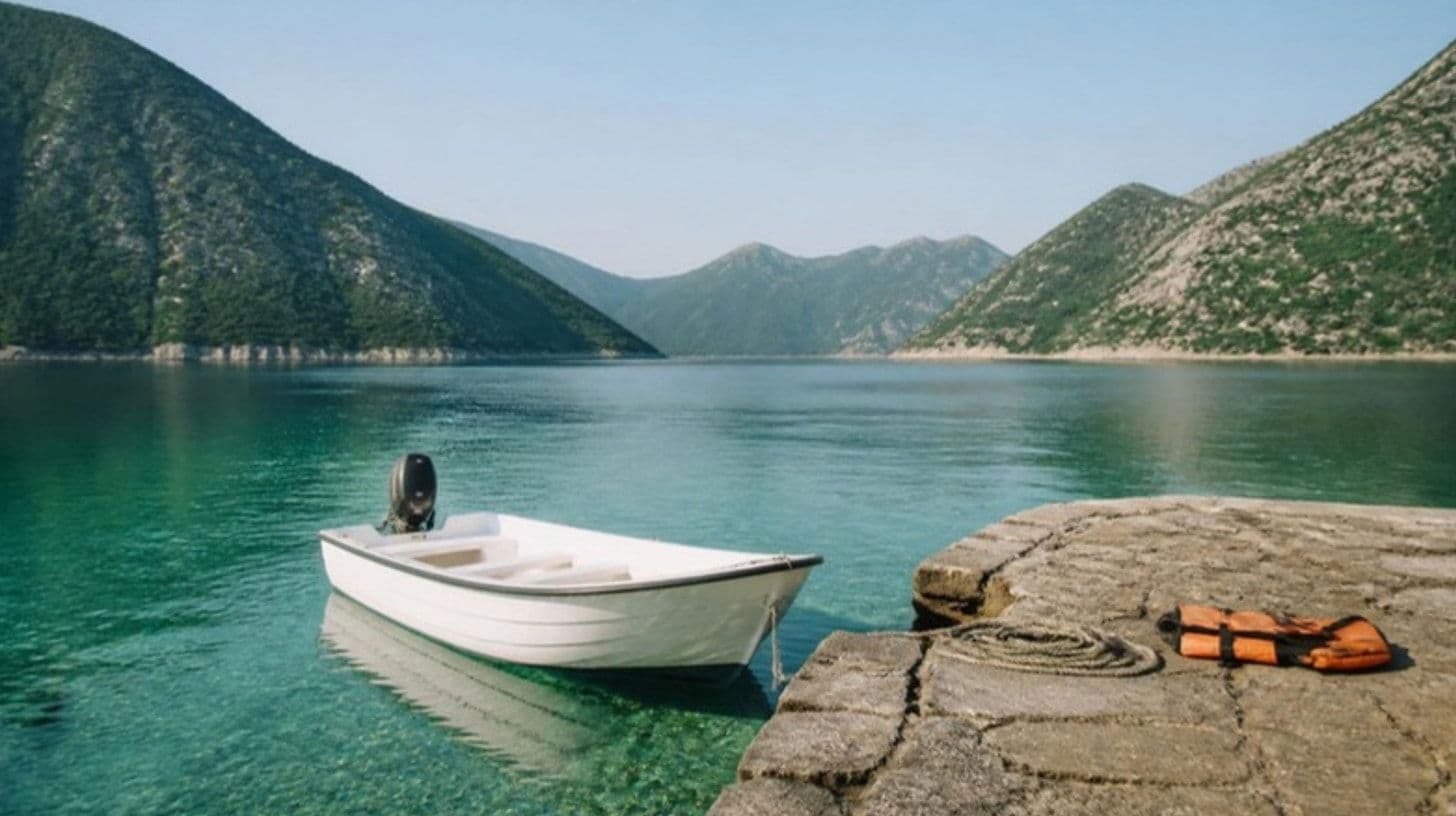 Ein kleines Motorboot an einer Steinmole in einer ruhigen Bucht