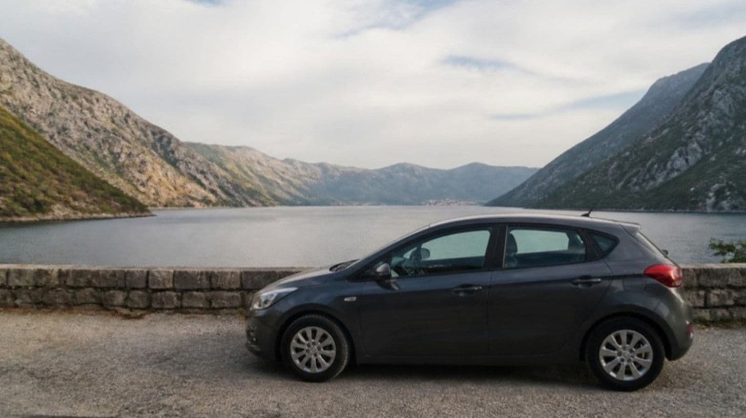 A car parked by the road above a bay