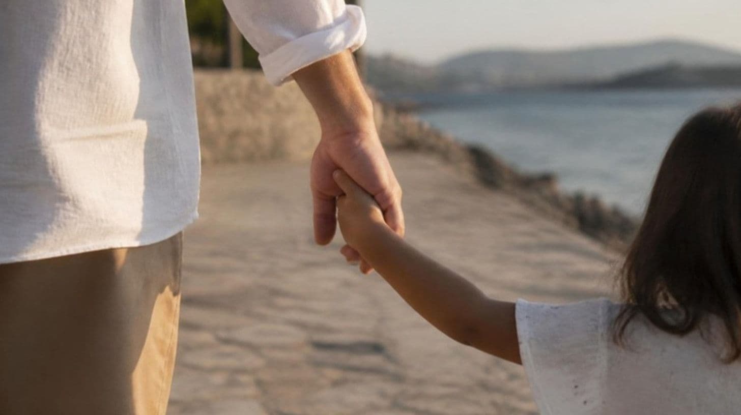 A child's hand in an adult's hand on a promenade